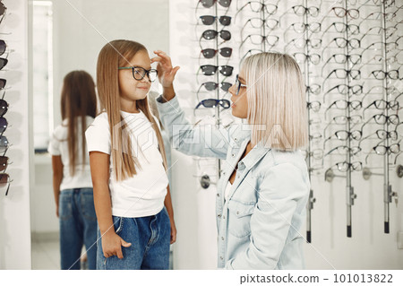 Mother with daughter. People in the store. Child in a white t-shirt. 101013822
