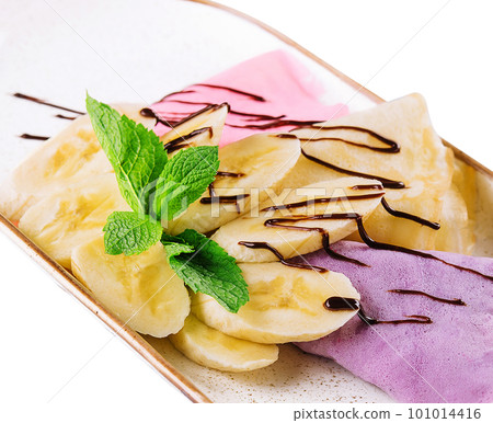 blueberry and raspberry pancakes with bananas and chocolate cream 101014416