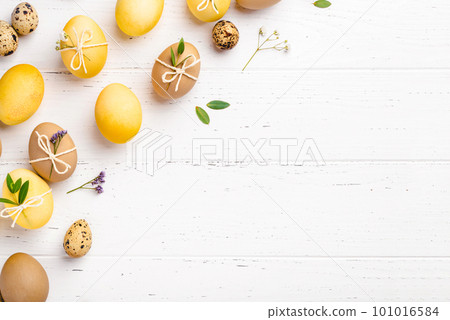 Easter eggs with flowers on a white table. 101016584