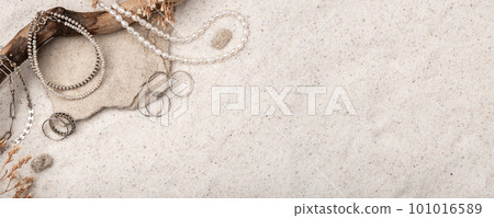 Beautiful Silver and Pearl Jewelry on white sand. 101016589