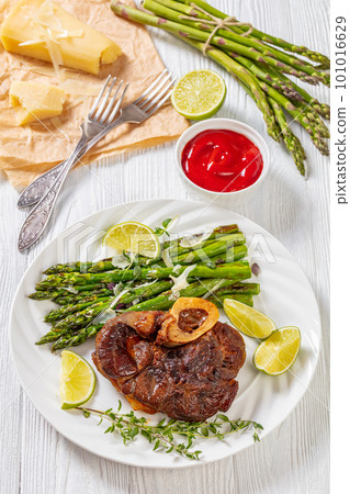 braised osso buco with grilled asparagus, top view 101016629