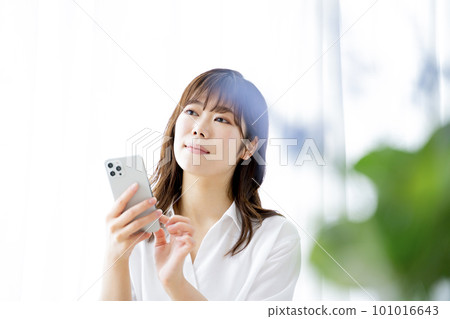 一個操作智能手機的年輕女子 101016643