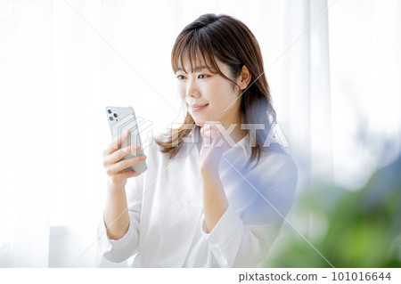 一個操作智能手機的年輕女子 101016644