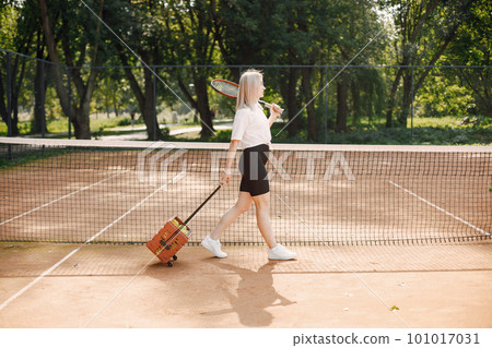 Tennis player going through tennis curt. Model posing. Hobbies, sports, equipment. 101017031