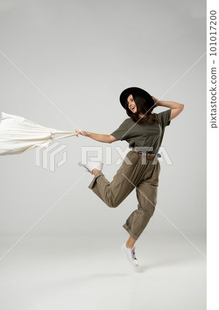 Zero waste concept. Happy young brunette woman in a green t-shirt and black hat jump with a cotton bag with groceries. Eco friendly lifestyle. Mockup. Zero waste concept. Happy young brunette woman in a green t-shirt and black hat jump with a cotton bag with groceries. Eco friendly lifestyle. Mockup. 101017200