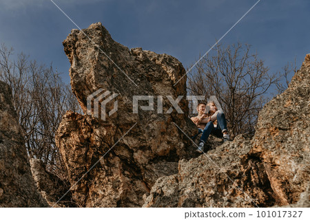 Mother and Child Sitting Together on Forest Rock 101017327