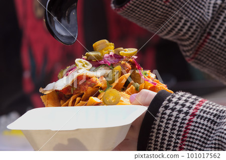 Woman holding plastic bowl of mexican food Woman holding plastic bowl of mexican food 101017562