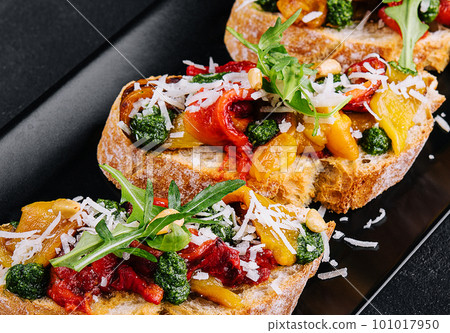 bruschetta with roasted peppers, pesto and parmesan cheese bruschetta with roasted peppers, pesto and parmesan cheese 101017950