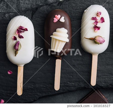 Top view of decorated cake pops ice creams on black background 101018327