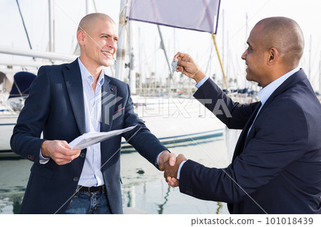 men with documents and keys near the yachts in the port 101018439
