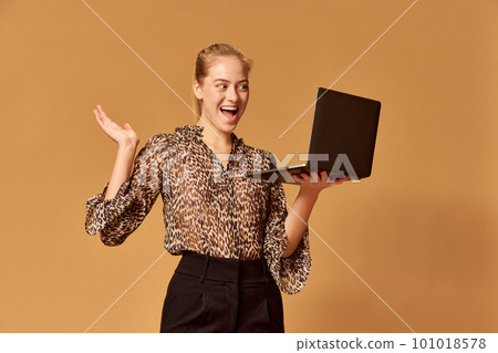 Portrait of remote young teacher woman talking and looking at webcam with excited face over orange background. Teaching students, doing video chat 101018578