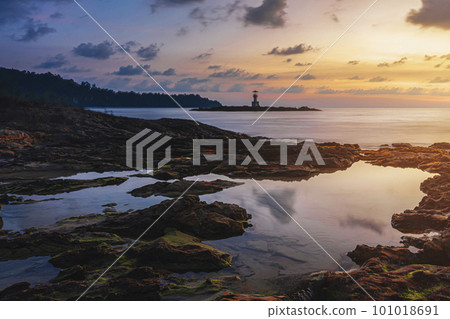 rocky coast on the beach in Khao Lak thailand , evening beautiful magical sunset lighthouse on the horizon , beautiful landscape photography 101018691