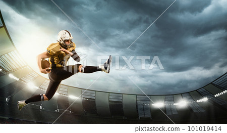 Motivated man, professional american football player in motion, catching ball. Open air 3D stadium in evening with spotlights. Game 101019414