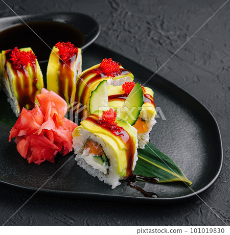 Green dragon sushi roll with eel on black stone Green dragon sushi roll with eel on black stone 101019830