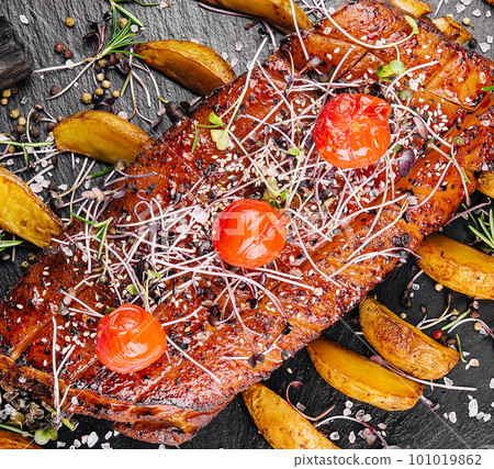 Tasty baked pork tenderloin in honey-orange glaze with potato wedges Tasty baked pork tenderloin in honey-orange glaze with potato wedges 101019862