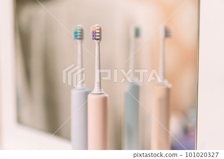 Electric toothbrushes in front of bathroom mirror Electric toothbrushes in front of bathroom mirror 101020327