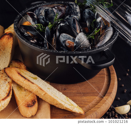 Traditional barbecue italian blue mussel in wine sauce with baguette bread 101021216
