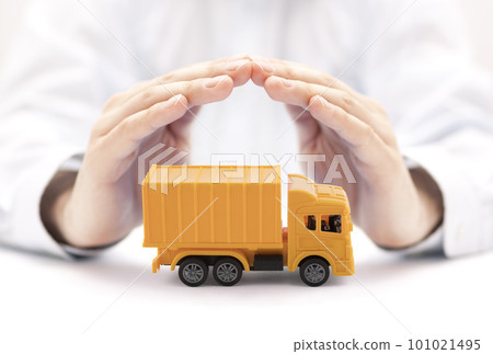 Yellow cargo delivery truck miniature protected by hands Yellow cargo delivery truck miniature protected by hands 101021495