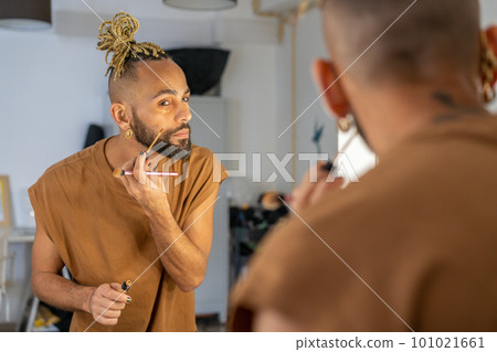 Black male gay applying make up Black male gay applying make up 101021661