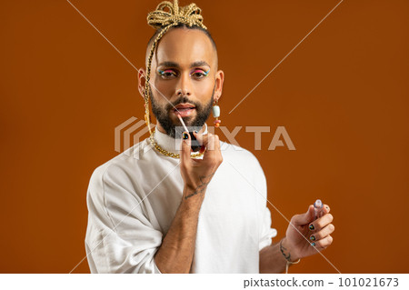 African american gay applying make up isolated on brown background 101021673