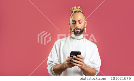 Black latin gay man with smartphone isolated on pink background 101021679