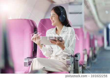 Beautiful Asian businesswoman working with digital tablet in aeroplane. working, travel, business concept Beautiful Asian businesswoman working with digital tablet in aeroplane. working, travel, business concept 101022256