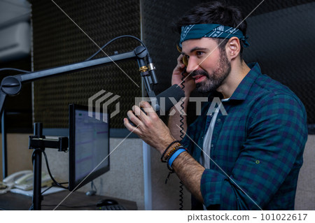 Young dark-haired dj looking contented at the studio 101022617