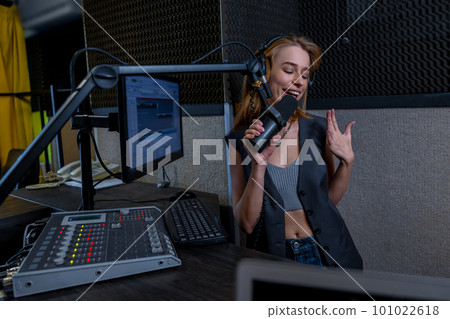 Young female singer singing at the record studio 101022618