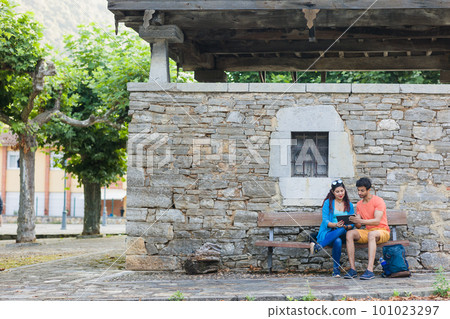 Asturias historical building Villanueva heritage. Mixed race couple together outdoor with tablet 101023297