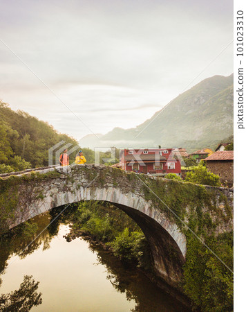 Trubia Asturias river bridge in Spain, Europa. mixed race latin and indian middle aged couple 101023310