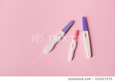 Top view of inkjet pregnancy test kits with a biochemical reaction between hCG and urine appearing in two bars, isolated pink color background. Ovulation day. Planning maternity. Gynecological concept 101023374