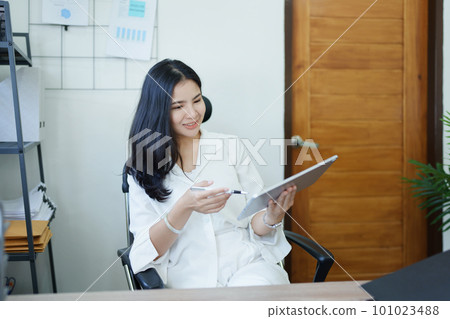 business owner or Asian female marketers are using tablet computer in office work. business owner or Asian female marketers are using tablet computer in office work. 101023488