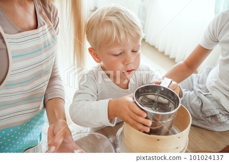Mom with two sons cooking holiday pie in the kitchen. Casual lif 101024137