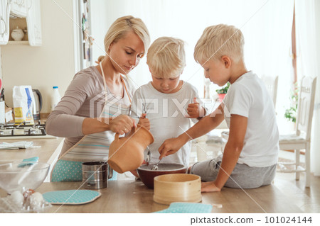 Mom with two sons cooking holiday pie in the kitchen. Casual lif 101024144