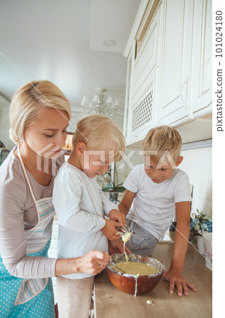 Mom with two sons cooking holiday pie in the kitchen. 101024180