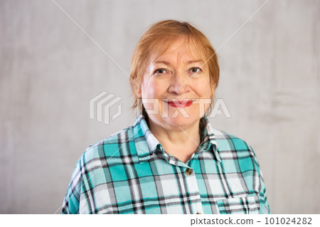 Smiling elderly woman in plaid shirt looking at camera 101024282