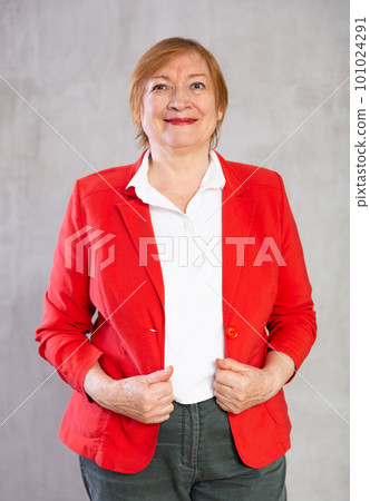 Happy mature lady standing with confident radiant smile Happy mature lady standing with confident radiant smile 101024291