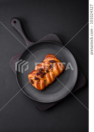 Delicious fresh baked pigtail bun with nuts and syrup 101024327
