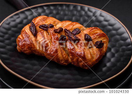 Delicious fresh baked pigtail bun with nuts and syrup 101024330