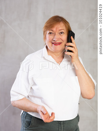 Senior woman taking phone call confidently with smile full of cheer 101024419