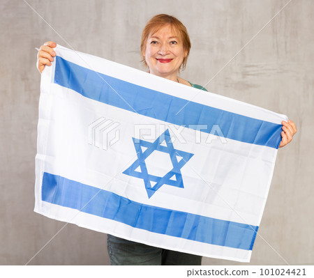 Happy senior woman waving national flag of Israel 101024421