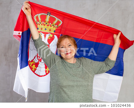Smiling senior woman waving national flag of Serbia Smiling senior woman waving national flag of Serbia 101024436
