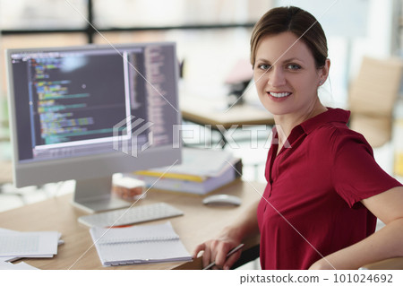 Smiling woman app developer writes code in company office 101024692