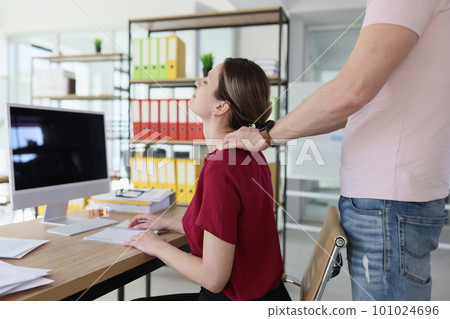 Colleague does neck massage to woman in company office 101024696