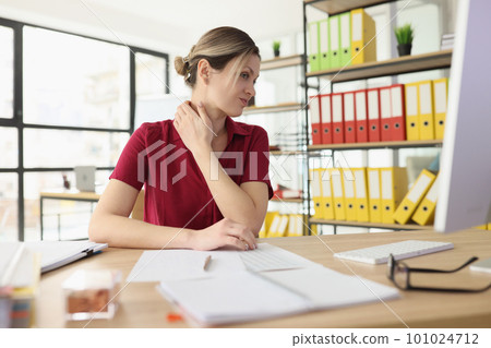 Woman employee suffers from pain in neck at office workplace Woman employee suffers from pain in neck at office workplace 101024712