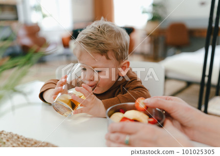 Little boy drinking tea, having snack with his grandmother. Little boy drinking tea, having snack with his grandmother. 101025305