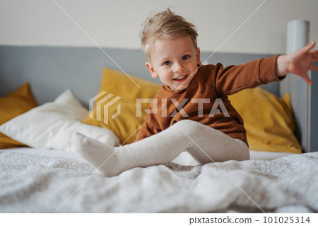 Portrait of little boy sitting on a bed. Portrait of little boy sitting on a bed. 101025314