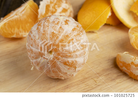 Peeled orange divided into slices on a board 101025725
