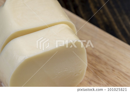 Soft cheese sliced into thick chunks on a cutting board Soft cheese sliced into thick chunks on a cutting board 101025821