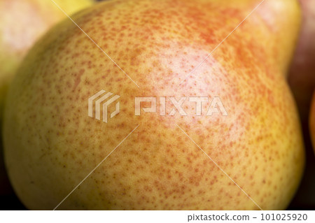 A yellow ripe pear with a red side on the table A yellow ripe pear with a red side on the table 101025920